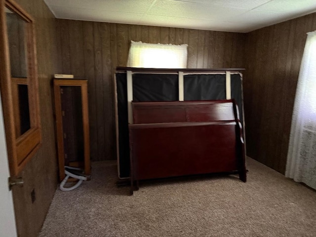 unfurnished bedroom with carpet flooring and wooden walls