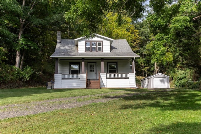 bungalow with a front lawn, a garage, a porch, and a storage unit