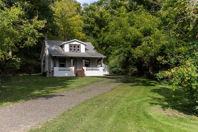 view of front of home with covered porch and a front lawn