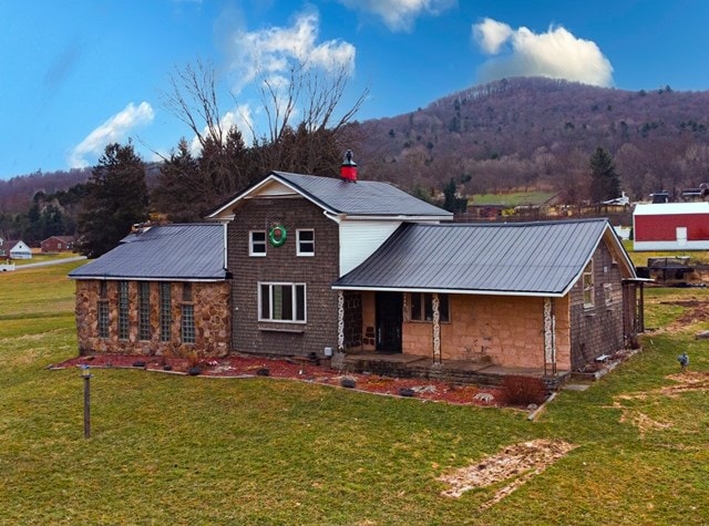 view of front of house with a mountain view, a patio area, and a front lawn