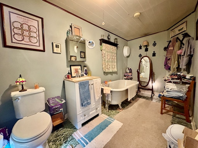 bathroom featuring toilet, a freestanding bath, and vanity