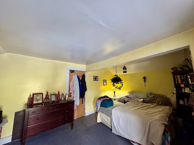 bedroom with vaulted ceiling and dark colored carpet