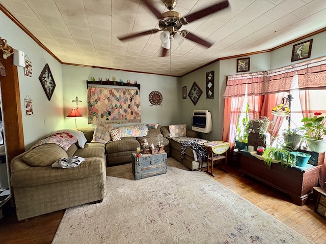 living area with ceiling fan, crown molding, heating unit, and wood finished floors