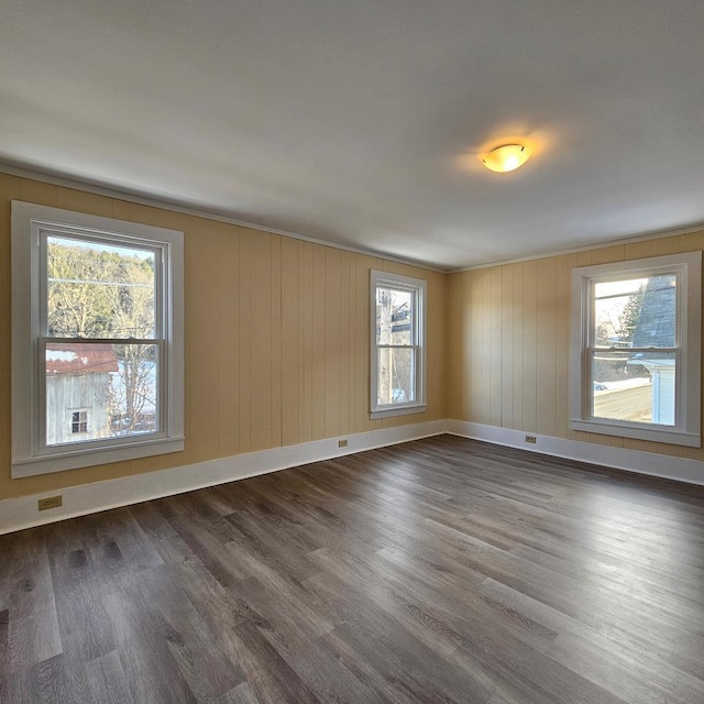 empty room with dark wood-type flooring and a healthy amount of sunlight