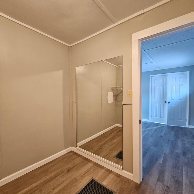 bathroom with crown molding and wood-type flooring