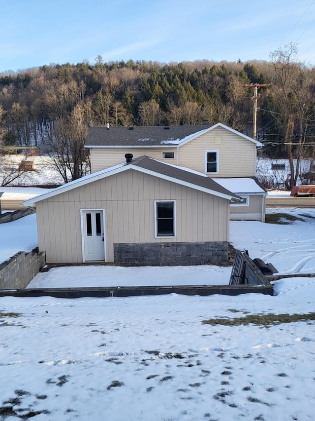 view of snow covered rear of property