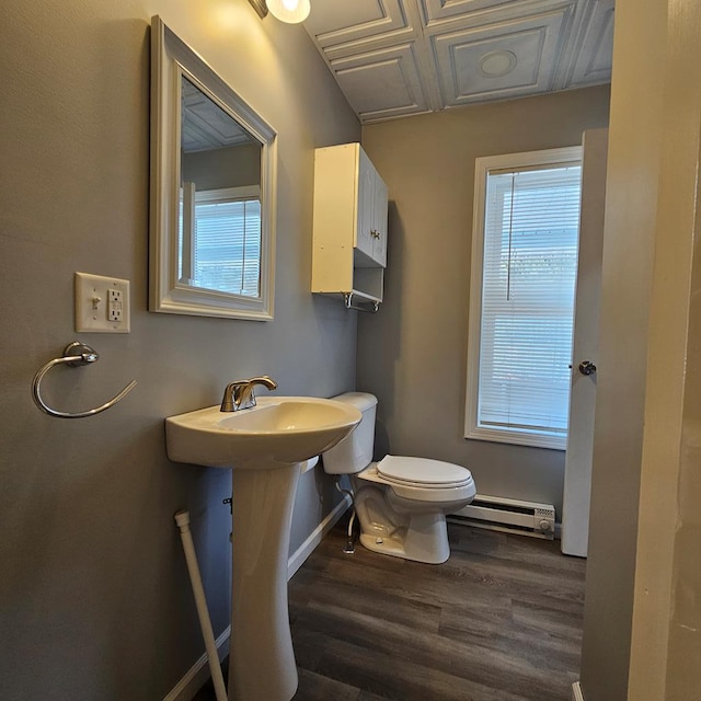 bathroom with a baseboard heating unit, wood-type flooring, and toilet