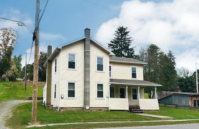 view of front facade featuring covered porch and a front yard