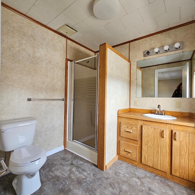 bathroom featuring crown molding, vanity, toilet, and a shower with door