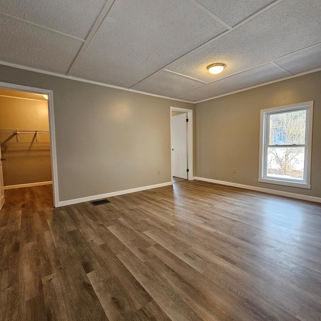 empty room featuring crown molding and wood-type flooring