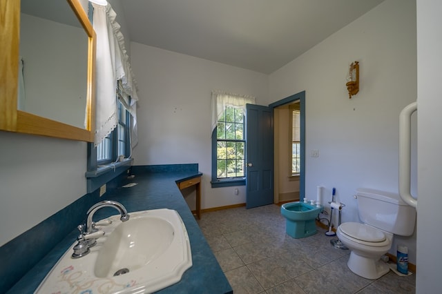 bathroom with tile patterned floors, toilet, a bidet, and sink