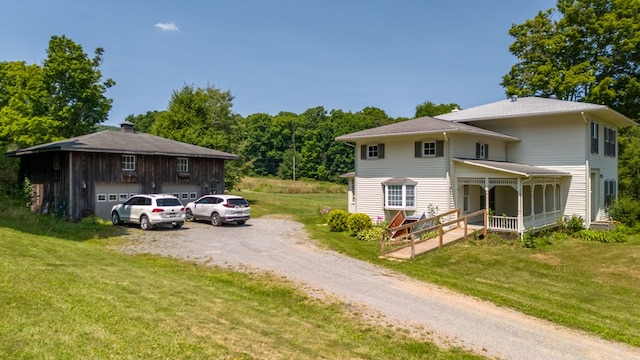 view of front of property with covered porch, a front yard, and a garage