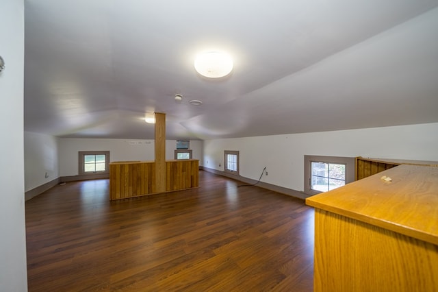 bonus room with dark hardwood / wood-style flooring, vaulted ceiling, and a wealth of natural light