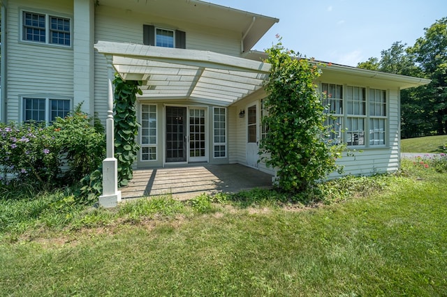 back of property with a patio area and a yard