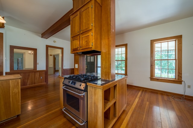 kitchen with tile countertops, stainless steel gas stove, beam ceiling, and dark hardwood / wood-style flooring