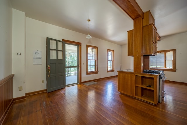 kitchen with kitchen peninsula, decorative light fixtures, dark wood-type flooring, and stainless steel gas range