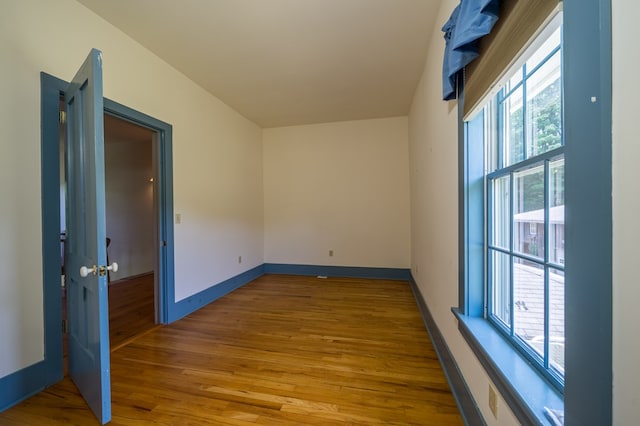 empty room with light hardwood / wood-style floors and a wealth of natural light