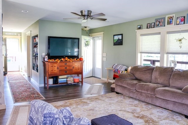 living room with dark hardwood / wood-style flooring and ceiling fan