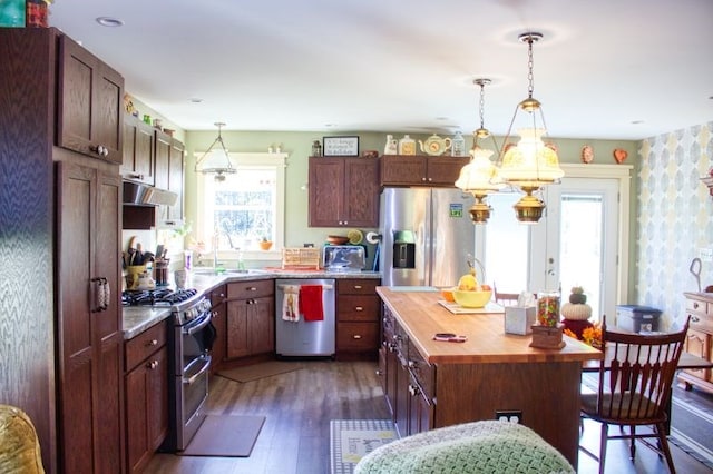 kitchen featuring sink, hanging light fixtures, dark hardwood / wood-style floors, a kitchen island, and stainless steel appliances