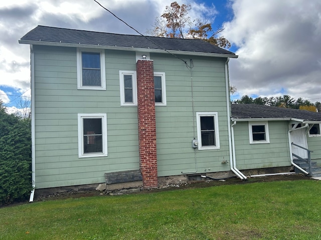 rear view of property featuring a yard