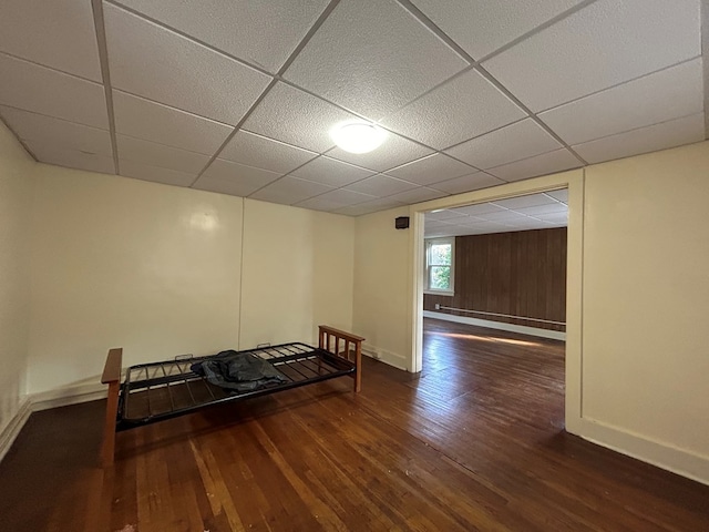 interior space featuring a drop ceiling and dark wood-type flooring