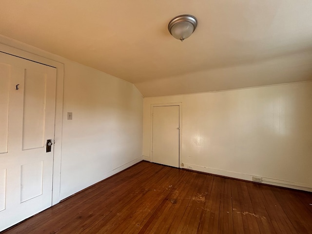 bonus room with vaulted ceiling and dark wood-type flooring