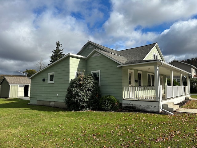 view of property exterior featuring covered porch, a storage shed, and a lawn