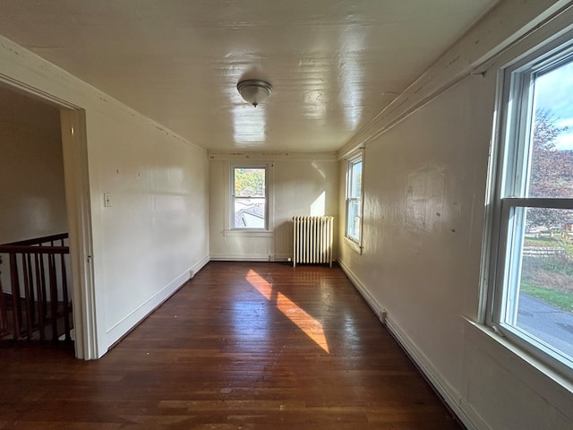 empty room featuring radiator heating unit and dark wood-type flooring