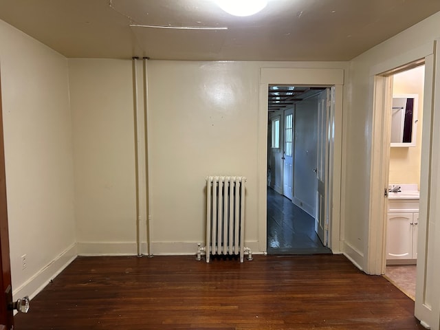 empty room with radiator and dark hardwood / wood-style floors