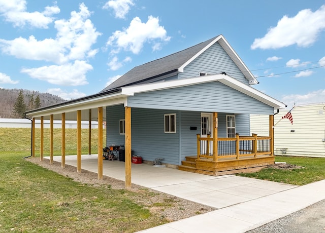 view of front of house with a carport, covered porch, and a front lawn