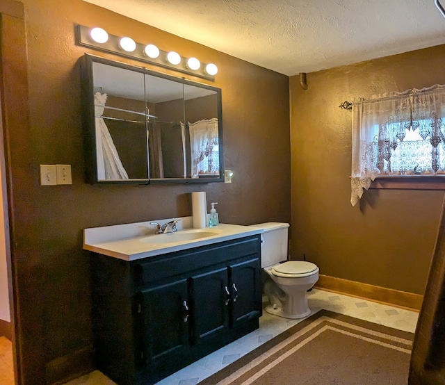 bathroom with vanity, a textured ceiling, toilet, and walk in shower