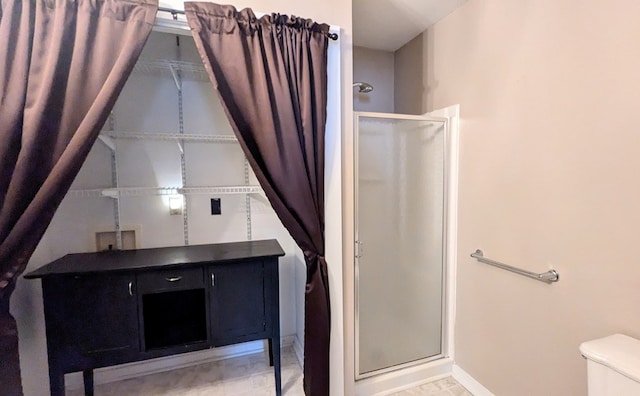 bathroom featuring an enclosed shower and toilet