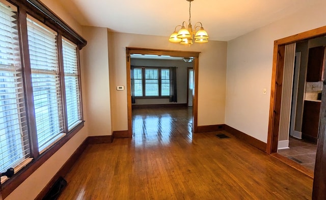 interior space featuring dark hardwood / wood-style floors and an inviting chandelier