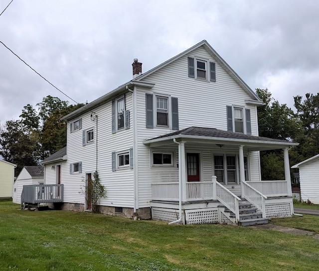 rear view of house featuring a lawn and a porch