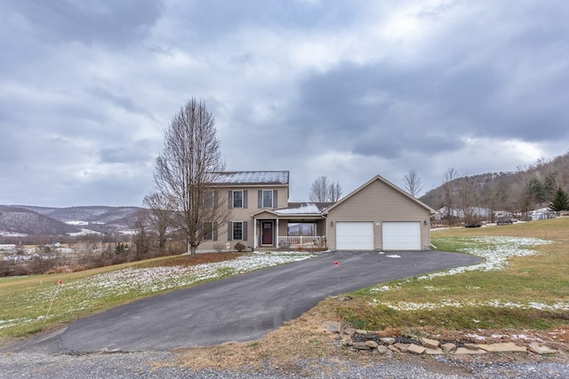 view of front of property with a mountain view, a front lawn, and covered porch