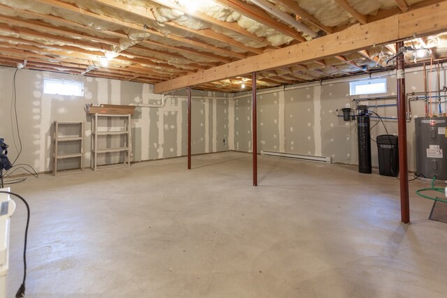 basement featuring a baseboard radiator and water heater