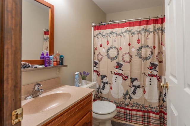 bathroom featuring curtained shower, vanity, and toilet