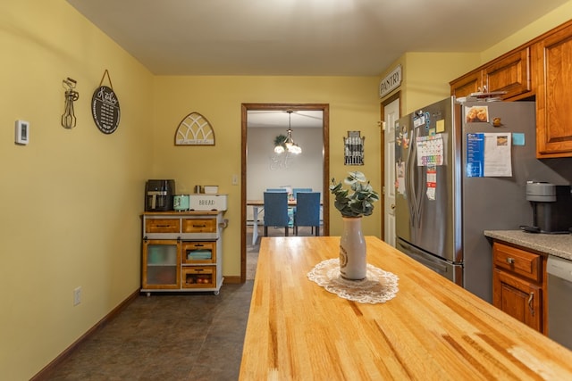 kitchen featuring butcher block counters, an inviting chandelier, pendant lighting, and appliances with stainless steel finishes