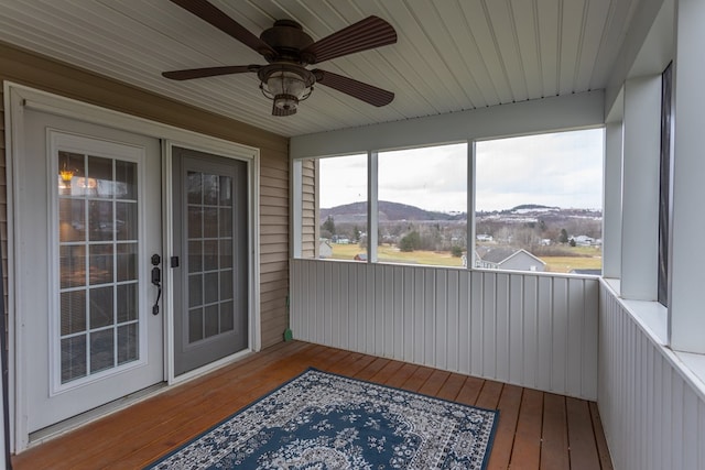 sunroom with a mountain view and ceiling fan