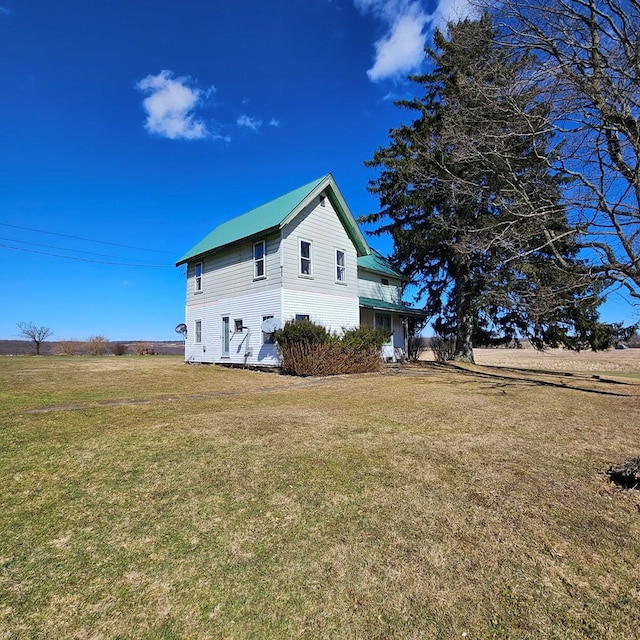 view of home's exterior featuring a yard and metal roof