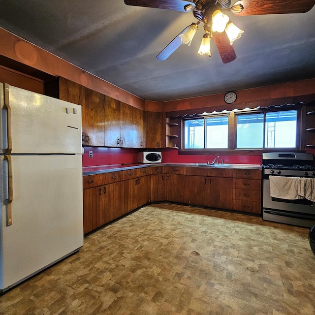 kitchen featuring plenty of natural light, ceiling fan, sink, and white appliances