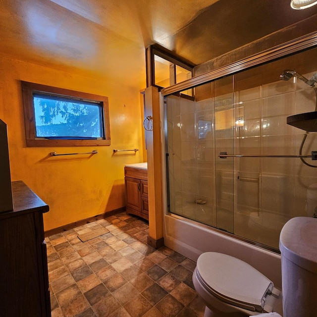 full bathroom featuring combined bath / shower with glass door, vanity, and toilet