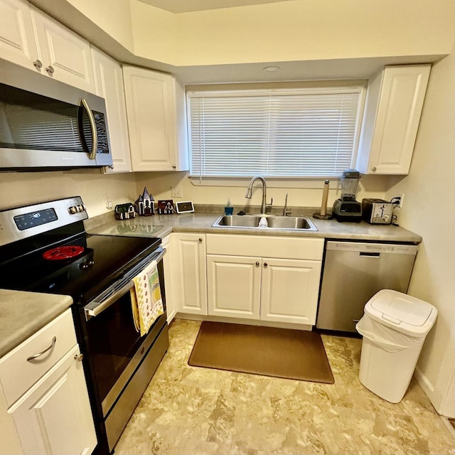 kitchen featuring stainless steel appliances, white cabinetry, and sink