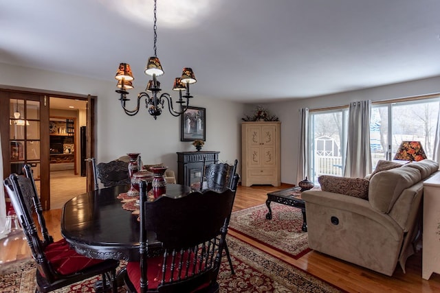 dining area with a notable chandelier and light wood-type flooring