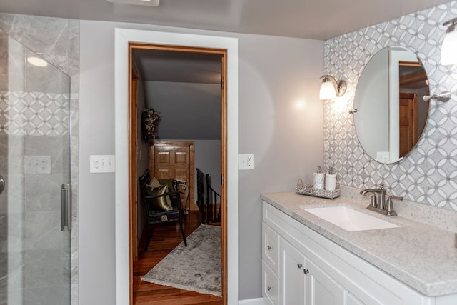 bathroom featuring vanity, a shower with shower door, and wood-type flooring