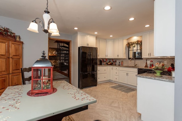 kitchen featuring hanging light fixtures, sink, white cabinets, and black appliances