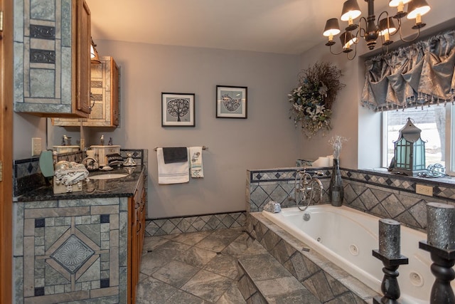 bathroom with vanity, a relaxing tiled tub, and a notable chandelier