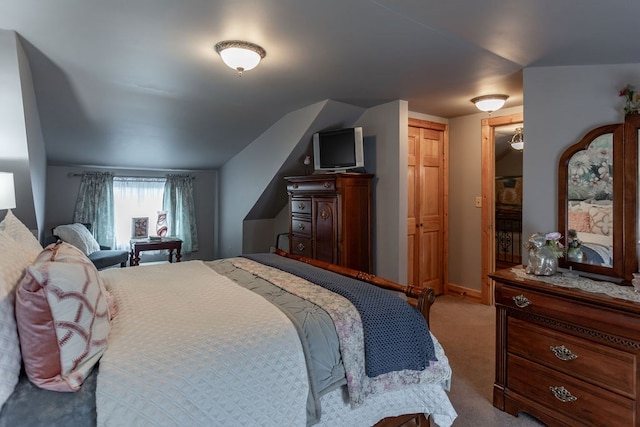 bedroom featuring lofted ceiling and carpet