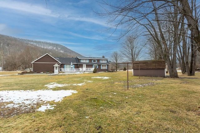 view of yard with covered porch, a mountain view, and a storage unit