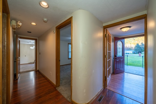 corridor featuring dark hardwood / wood-style floors and a textured ceiling